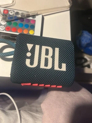 JBL Go 3 - Kompakt och portabel Bluetooth-högtalare från JBL i blått och rosa . Snygg design med tydliga knappar och slitstark yta. Perfekt för musik på språng, vattentålig och med bra ljudkvalitet. Inga synliga defekter eller slitage på bilderna INGÅR EJ USB C LADDARE DÄR AV PRISET . Priset kan diskuteras lite