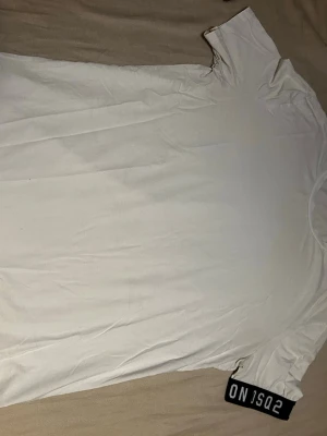 Vit t-shirt från DsQuared2 - Säljer en enkel och stilren vit t-shirt från     DsQuared2. T-shirten har korta ärmar och rund hals. Materialet känns mjukt och skönt, troligtvis bomull. Perfekt för dig som gillar cleana och minimalistiska plagg.