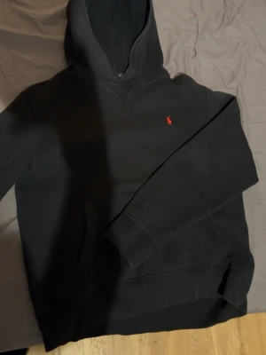 Polo Ralph Lauren hoodie med röd logga - En svart polo Ralph lauren hoodie med rött märke och en insida.