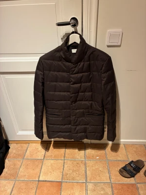 These Glory Days vinterjacka - Quiltad brun dunjacka från These Glory Days i storlek Small. Jackan har en kavajliknande form med knappar framtill och två fickor. Materialet är mjukt och matt, perfekt för kyliga dagar. Snygg att bära över hoodie eller tröja. Jackan är använd typ 5 gånger och är i ett perfekt skick. Nypriset när jag köpte den låg på 2799 kr. Mitt pris är 999 kr. Men kan gå ner i pris vid snabb affär.