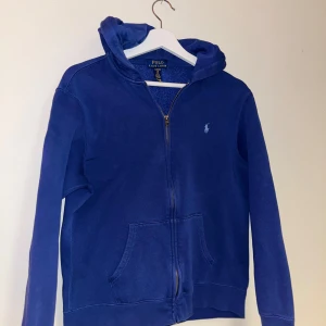 Polo ralph lauren zip - Blå ralph lauren zip hoodie med ljusblå detaljer. QR kod finns för att bevisa att den är äkta. Storleken är XL i barn men passar som XS-S i vuxen.
