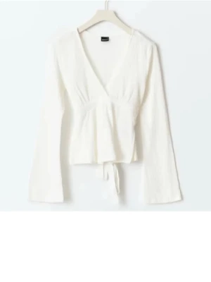 Vit knyt topp Gina Tricot - Säljer en vit omlottblus från Gina Tricot med v-ringning och långa ärmar. Blusen har knytband i midjan som går att knyta på baksidan och framsidan. 