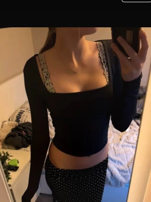Lila långärmad croppad topp AMISU - Säljer en svart långärmad topp från AMISU med fyrkantig halsringning och croppad passform. Toppen är stilren och har en tight siluett som framhäver midjan. Perfekt att matcha med höga jeans eller kjol för en trendig look.