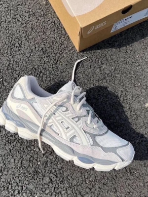 Vita och grå ASICS sneakers - Säljer ett par fräscha ASICS sneakers i vitt och ljusgrått med mesh och mockadetaljer. Skorna har snörning, rund tå och platt sula. Perfekta för dig som gillar stilrena och sportiga sneakers med snygg design.