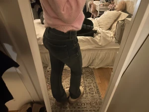 Mörkblå bootcut jeans - Säljer ett par mörkblå jeans med bootcut-modell och klassisk femficksdesign. Jeansen har normal passform och är tillverkade i ett mjukt denimtyg som sitter snyggt över höften och låret. Perfekta till sneakers eller boots.