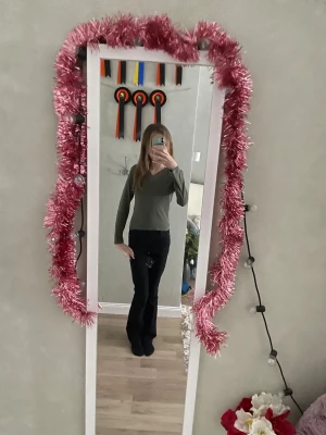 Olivgrön långärmad topp från Gina Tricot - Säljer en olivgrön långärmad topp från Gina Tricot med snygg v-ringning och spetsdetaljer i halsen. Toppen har en normal passform och är gjord i mjuk bomull, perfekt för dig som gillar stilrena och bekväma plagg. Fräsch färg som passar till mycket!