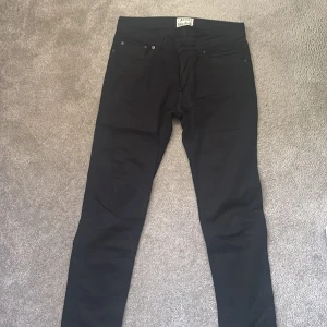 Svarta jeans från Acne Studios - Svarta jeans från Acne Studios, modell Ace Stay cash. Klassisk femficksdesign med smal passform och dragkedja. Snygga och stilrena byxor i svart bomullsmix, perfekta till en clean look. Stl 31/32