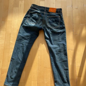 Blå jeans från Jacob Cohen - Snygga blå jeans från Jacob Cohen med klassisk femficksdesign, kontrastsömmar och läderpatch bak i midjan. Jeansen har en rak passform och är tillverkade i mjukt denimtyg med lätt tvättad look och slitningar för en cool vibe.