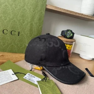 Svart keps från Gucci  - Snygg svart keps från Gucci med diskret GG-mönster i samma ton. Kepsen är tillverkad i canvas med detaljer i skinn och har justerbar rem baktill. Perfekt accessoar för en trendig look och passar till många outfits.
