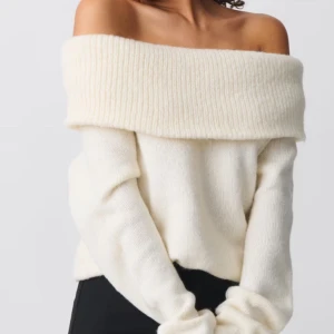 Offshoulder stickad vit tröja från Ginatricot - KÖPT FÖR 399! Superfin offshoulder stickad tröja i mjuk vit ullmix. Tröjan har bred ribbad kant upptill som ger en snygg och avslappnad look. Perfekt att styla med jeans eller kjol för en trendig vibe.