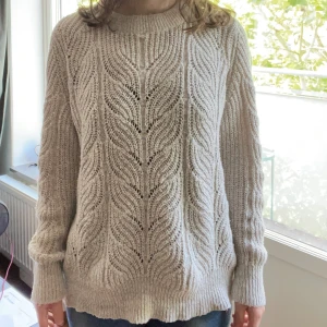 Beige stickad tröja från Object XL - Säljer en beige stickad tröja från Object i storlek XL. Tröjan har ett snyggt, flätat mönster och bred ribbad kant vid halsen, ärmslut och nederkant. Perfekt för dig som gillar en chill och cozy stil under höst och vinter.