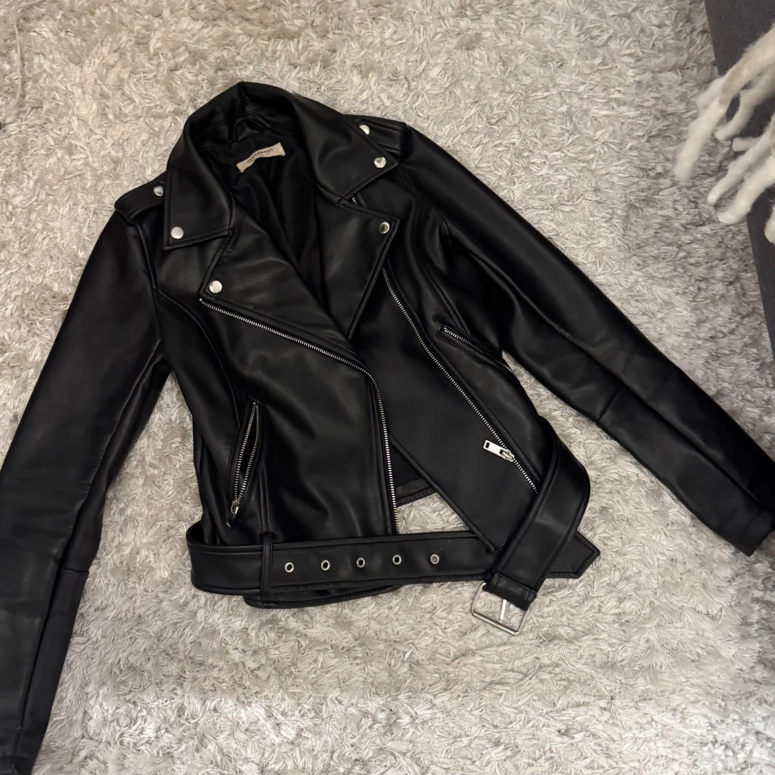 Svart skinnjacka med bälte och dragkedjor