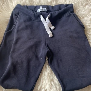 Mörkblå mjukisshorts med snörning S - Mörkblå mjukisshorts från R i storlek S. De har en bred resår i midjan och vit snörning framtill för extra komfort. Shortsen har två sidofickor och är tillverkade i mjukt bomullsmaterial, perfekta för chill eller träning.