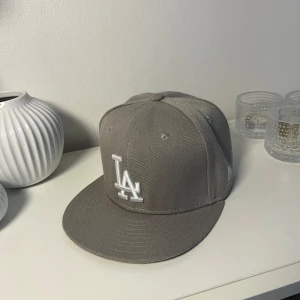 Grå LA Keps - Säljer en fet grå LA Keps. Strl 56,8