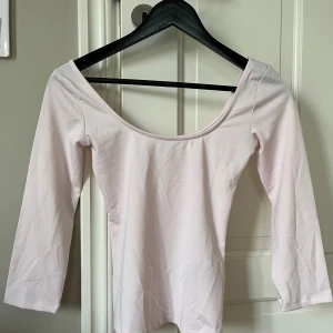 Ljusrosa från Nelly - Supersöt ljusrosa topp från Nelly med bred, djup ringning och trekvartsärm. Sitter snyggt och har en enkel, stilren look som är lätt att matcha. Gjord i mjukt och stretchigt material för en bekväm passform.