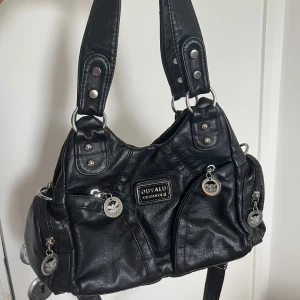 Svart axelväska  - Svart axelväska med flera dragkedjefickor och silvriga detaljer. Jätte fin, aldrig använd!