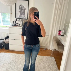 Svart figursydd tröja från Nelly  - Säljer denna jättefina figursydda T-shirten från Nelly i svart. Den är i storlek XXS men passar säkert XS och S med 