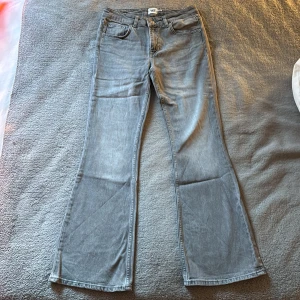 Gråa lowboot jeans från lager 157 - Gråa jeans från lager 157. Jeansen är gjorda i denim och har en low, bootcut passform med utsvängda ben. Det är klassiska 5 fickor med gylf och knapp. Stilren design gör att jeansen passar till allt och alla. Aldrig använda. Säljer pga fel storlek. Pris kan diskuteras. skriv för fler bilder. 
