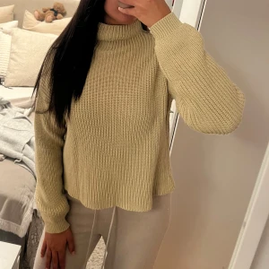 Beige stickad polotröja - Beige stickad polotröja med ribbad struktur och lång ärm. Tröjan har en kort krage och en lite loose passform🩷