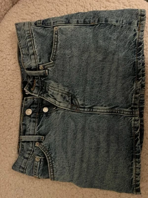 Blå jeanskjol från 157 - Säljer en klassisk blå jeanskjol från 157 med femficksmodell, bälteshällor och dubbla silverknappar fram. I storlek XXS men passar XS/S också💞Endast använd ett fåtal gånger!