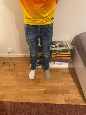 Blå skinny jeans med slitningar - Snygga blå skinny jeans med slitningar och lätt tvättad look. Jeansen har klassisk femficksdesign och låg midja. Perfekta för en avslappnad och trendig stil. Dsquerd2 äkta original pris 2500 kr 