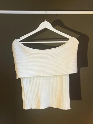 Vit off shoulder stickad topp - Trendig vit stickad topp med bred off shoulder-krage och ribbad struktur. Kortare modell som sitter snyggt på kroppen och passar perfekt till både jeans och kjol. Mjuk och stretchig kvalitet för en bekväm känsla. Köpt från SHEIN, aldrig använd🤍