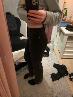 Svarta bootcut jeans med hög midja - Säljer ett par svarta bootcut jeans med hög midja. Jeansen har klassisk femficksdesign och sitter snyggt över höfterna innan de blir vidare nedtill. Perfekta för dig som gillar en tidlös och trendig look.