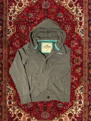 Hollister cardigan med luva! - Säljer denna hollister cardigan/hoodien | Storlek L | Mycket bra skick | Längd ≈65cm | Bredd ≈ 50cm | Passar 175cm - 190cm | Hör av dig vid fler frågor!