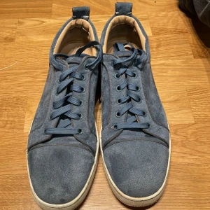 Blå sneakers i mocka med snörning - Snygga blå sneakers i mocka med klassisk snörning och vit sula. Skorna har rund tå och lågt skaft, vilket ger en clean och stilren look. Perfekta för dig som gillar en avslappnad men ändå trendig stil.
