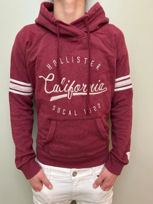 Vinröd hoodie från Hollister!!! - Snygg vinröd vintage hoodie!! Passar perfekt till chill och sköna outfits. Märke:Hollister. Size M men passar även  S!! Skick 9/10!! Model 176cm/väger 64kg