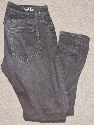 Mörkgrå Dondup george - Snygga mörkgrå jeans med klassisk femficksdesign och raka ben. Jeansen har en enkel look utan synliga loggor på bakfickan och är perfekta för en avslappnad stil. Tillverkade i mjukt denimtyg för skön känsla. 36l 32w passra ca 180 cm