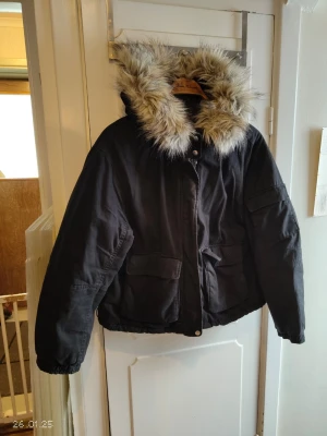 Jacka - Svart jacka med pälskant på luvan. Strl M