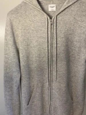 Ljusgrå zip hoodie från John Henric, Kashmir - Ljusgrå hoodie i kashmir från John Henric, köpt för 2490kr. Skicket är bra 8/10 men ett litet hål som inte syns men kan fixas lätt om man vill. 