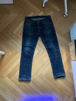 Nudie jeans - Ett par nudie jeans i storlek 33 34, det är hål i båda fickorna och ett litet i skrevet. Jag har även sytt upp dem typ 2 cm. Annars har dom feta slitningar och najs passform. Grimtim är  modellen.