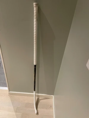Svart och vit innebandyklubba Zone - Säljer en stilren innebandyklubba från Zone med svart skaft och vit grepplinda samt vit blad. Greppet har ett snyggt mönster och klubban har Zone-loggan i gult på skaftet. Perfekt för dig som vill ha en schysst look på planen -rightfattad 100cm.  Inga fel på klubban (blivit för kort för mig). Supremeblad på + går att köpa med flera hyperblad (150kr/st). Finns två klubbor till i min profil, du får alla tre för 1500.