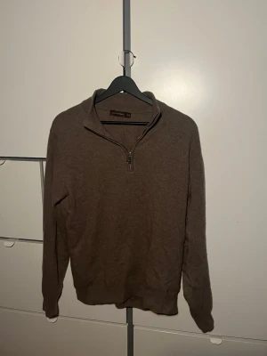 Brun half zip från Oscar Jacobson - Snygg brun stickad tröja från Oscar Jacobson i storlek M. Använd ungefär 5 gånger sen har den mest hängt i gaderoben:)