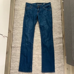 Blå lågmidjade jeans från Miss Sixty - Snygga blå raka lågmidjade jeans från Miss Sixty med klassisk femficksdesign och knappgylf. Tillverkade i Italien av bomull och elastan för en bekväm passform. Kolla den andra annonsen eller skriv för fler bilder 🤍