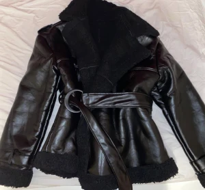 Svart teddyjacka/kappa skinnjacka - Säljer en oversize skinnjacka  den saknar märkning och jag kan därför inte bekräfta var den är köpt eller vilket märke den tillhör. Storleken är inte angiven, men uppskattas motsvara cirka M/L–XL.