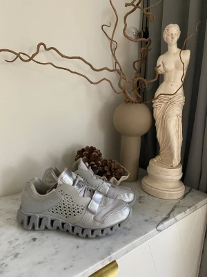 Emporio Armani × Reebok EA7 sneakers 43 – exklusiva - Ett unikt samarbete mellan Emporio Armani och Reebok – där Armanis premiumdesign mötte Reeboks tekniska sport-DNA. Resultatet? En sneaker som är lika mycket statement som skor. De här EA7-skorna i storlek 43 andas kvalitet rakt igenom. Lätta, bekväma och med den där exklusiva känslan som bara uppstår när två världar möts på riktigt. De tillverkades i mindre upplaga, så chansen att hitta ett par i så här fint skick är… ja, ganska liten. I mycket bra skick!