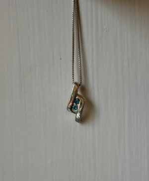 silverfärgat hängsmycke med blå stenar - unikt hängsmycke i silverfärg med blå stenar 