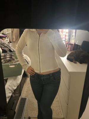 Vit ribbad cardigan långarnad tröja S - Vit ribbad cardigan jacka från 157 i storlek S. Jackan har dragkedja framtill, lång ärm och en croppad passform. Perfekt för dig som gillar en clean och enkel stil med lite edge. Materialet är mjukt och stretchigt, vilket gör den superbekväm.