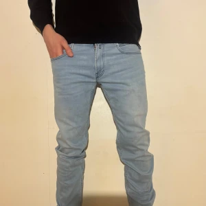 REPLAY JEANS   - REPLAY jeans i en stilren ljusblå färg med en riktigt snygg och original jacronlapp. En tidlös slim fit-modell som funkar till allt. Storlek W32/L34 och jag hjälper gärna till om du är osäker på passformen❗️Skriv bara så svarar jag snabbt❗️ 🚨Detaljer:  Märke: REPLAY • Modell: AMBAS • Färg: ljusblå • Skick: fint vintage-skick 📐Mått • Midja (A): 42 cm • Benlängd (B): 109 cm