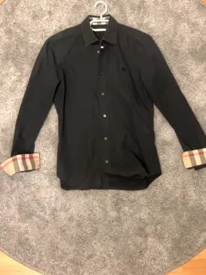Skit grisch och fet Burberry skjorta med mönster på armar och krage. Pris kan diskuteras vid snabb affär!
