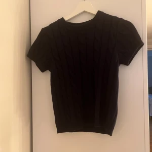 Kabelstickad tröja! - Säljer en svart kabelstickad tröja med korta ärmar och klassiskt kabelstickat mönster. Från gina i storlek 158/164. Nyskick💕