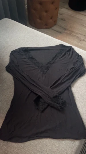 Svart långärmad topp med spets intimissimi  - Svart långärmad topp med snygg v-ringning och spetsdetaljer både vid halsen och ärmsluten. Tunn och mjuk i materialet. Tröjan är ifrån intimissimi och är i storlek S. Kan gå ner i pris vid snabb affär! Skriv om du har några frågor eller om du vill ha mer bilder, till exempel hur den ser ut på, då löser jag det!❤️
