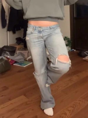 Populära lågmidjade Zara jeans  - Säljer mina snygga ljusblå jeans från Zara med låg midja. Jeansen har slitna detaljer och hål på båda benen. Använda endast 1 gång så super skick! (Lånad bild men exakt samma jeans) skriv om ni har frågor! 