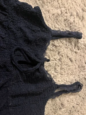 Blå topp - Blå topp från Gina tricot med spets på band och toppen. Den har även band som är sjusterbara och en utsvängd look.