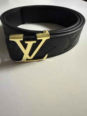 Svart Louis Vuitton bälte med guldspänne - Säljer ett svart Louis Vuitton bälte i skinn.  Tveka inte på att höra av er vid minsta fundering.