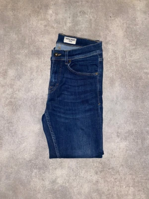 Blå tiger of Sweden jeans  storlek 29/30 - Snygga mörkblå jeansbyxor från tiger of sweden .Modellen har rak passform och normal midja, vilket ger en clean och tidlös look. Perfekt för dig som gillar stilrena och bekväma jeans.