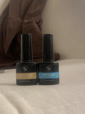 HW Professional Base & Top Coat - Två flaskor nagelprodukter från HW Professional, en Base Coat med guld etikett och en Top Coat med blå etikett. Båda är soak off UV/LED och innehåller 7,5 ml vardera. Perfekt för gelnaglar och snygg finish.